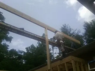 Carpenter setting a ridge beam over a new addition frame — Ice Dam Removal by Roofing Brothers in Duncan