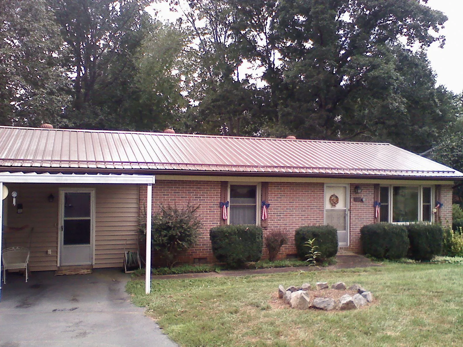 Bronze metal roof and carport on a brick ranch home — Roof Repair work by our crew in Duncan